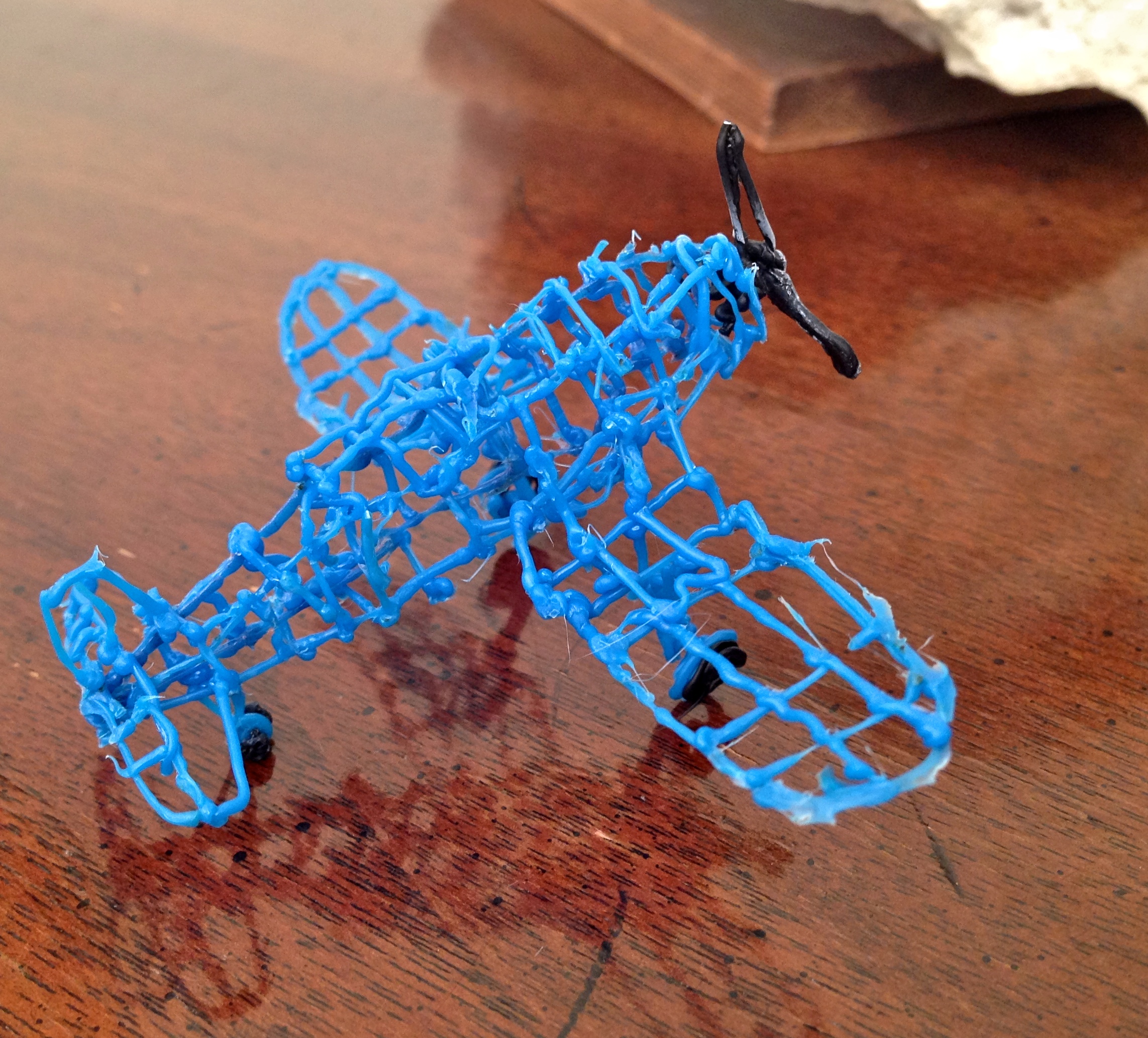 Pictured is a blue airplane with a black propeller made from 3-D print filament.