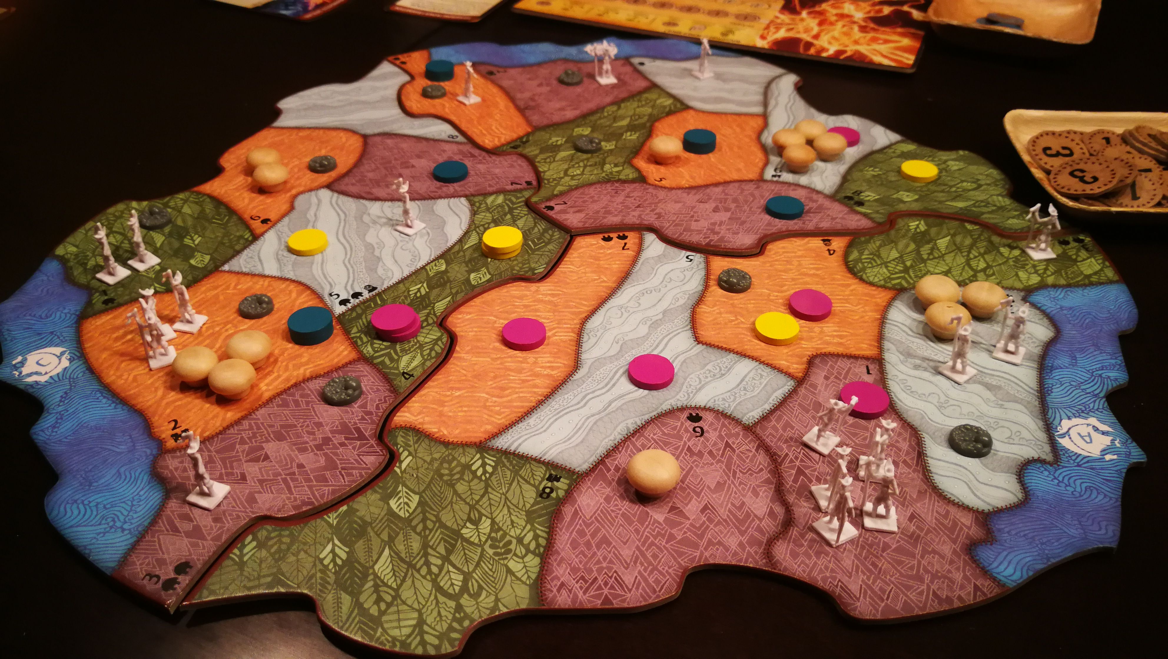 An image of the Spirit Island board game, which includes landmasses and pieces of various vibrant colors.